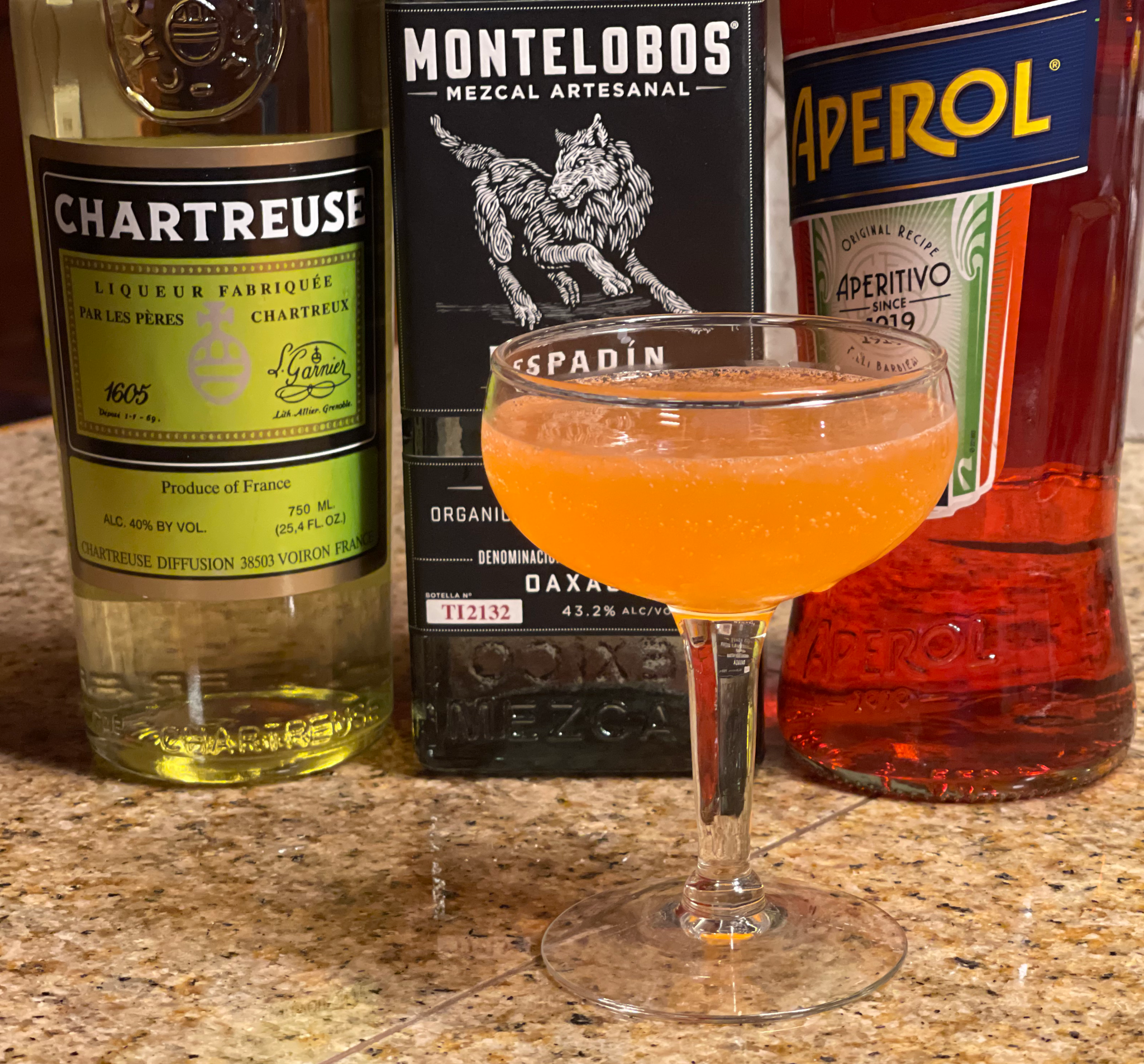 Naked and Famous cocktail: a orange-colored cocktail in a coupe